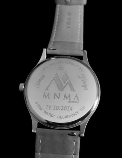 Uhr mit Gravur von MNMA auf Rückseite